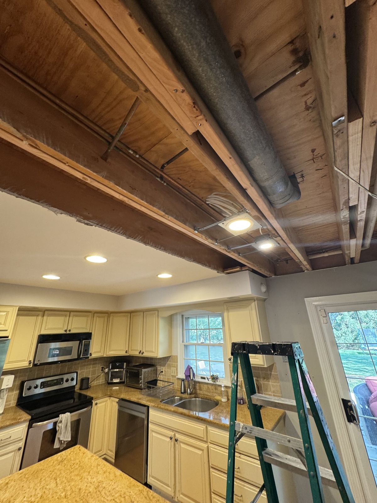 The old kitchen before the remodel: oak cabinets, laminate counters and the ceiling opened up